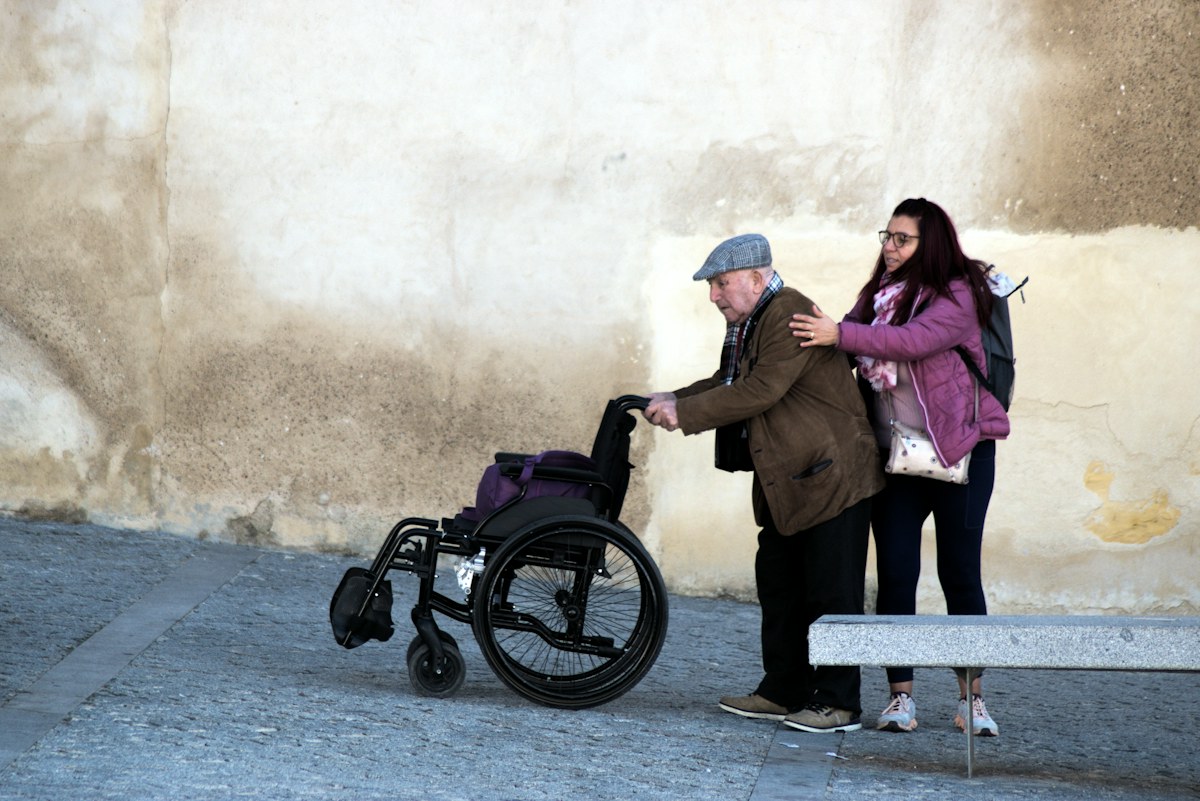 A woman supporting an older man during an outing